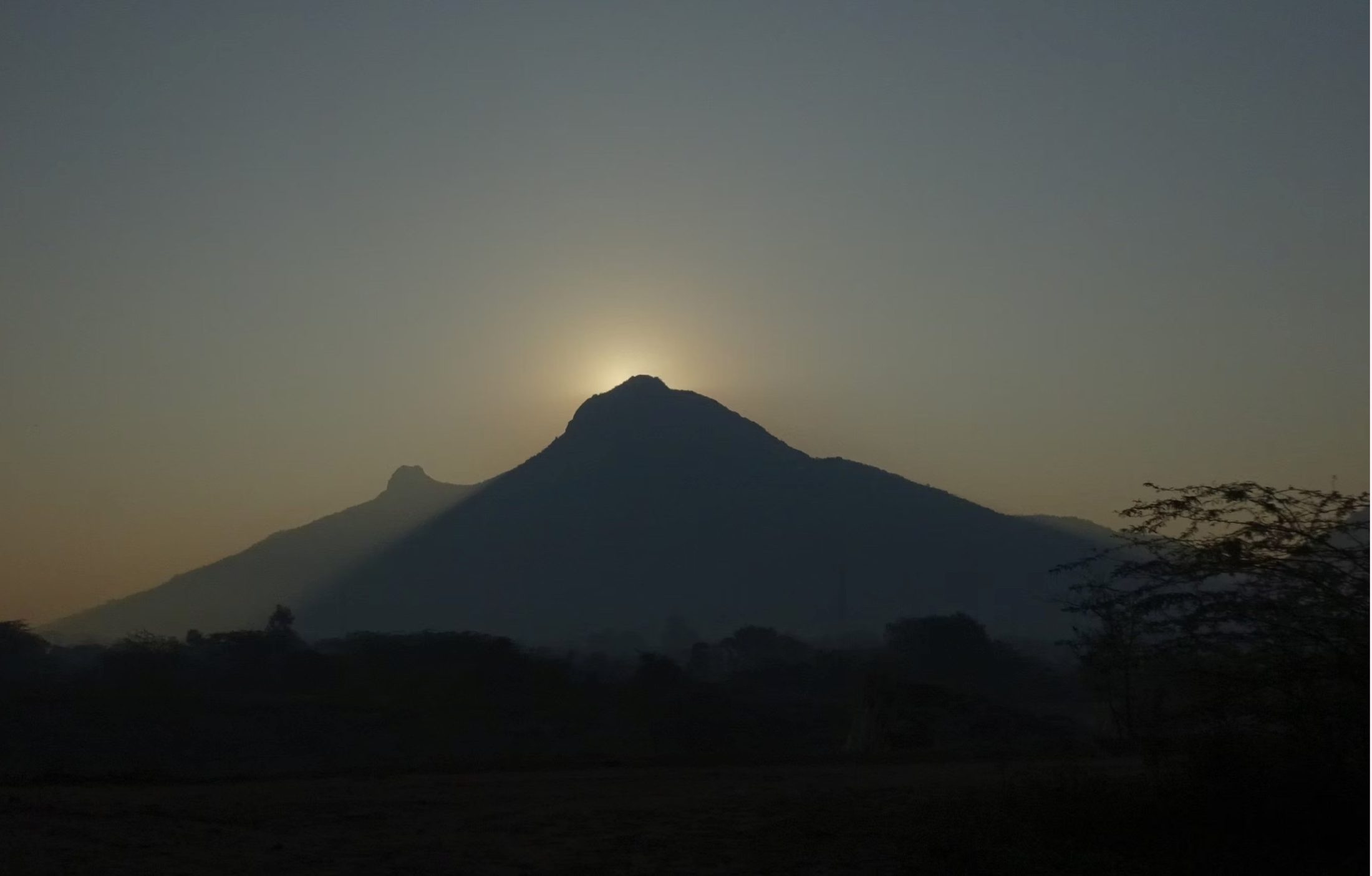 The sun rising directly behind the peak of Arunachala